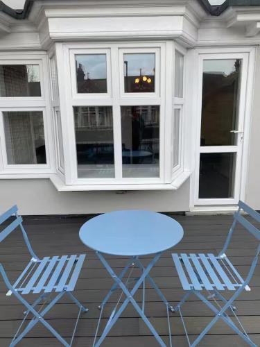 two chairs and a blue table on a porch at Dream Yard Apartments in Southend-on-Sea