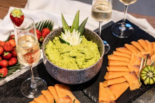 a plate of food with a bowl of guacamole and fruit at Marins Naiya Boutique Hotel in Cala Bona