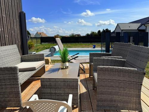 een terras met stoelen en een tafel en een zwembad bij Tiny house - piscine et vélos in Vasselay