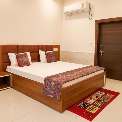 a bedroom with a large bed with a wooden headboard at Shri Radha Kunj Vrindavan in Vrindāvan