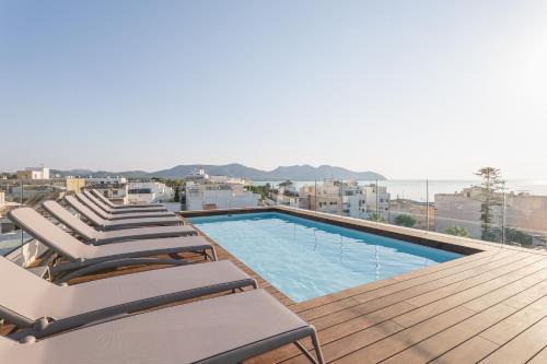 a swimming pool with lounge chairs on a roof at Marins Naiya Boutique Hotel in Cala Bona