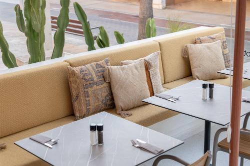two tables sitting on a couch in a restaurant at Marins Naiya Boutique Hotel in Cala Bona