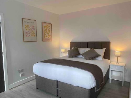 a bedroom with a large bed with two tables and two lamps at Dream Yard Apartments in Southend-on-Sea