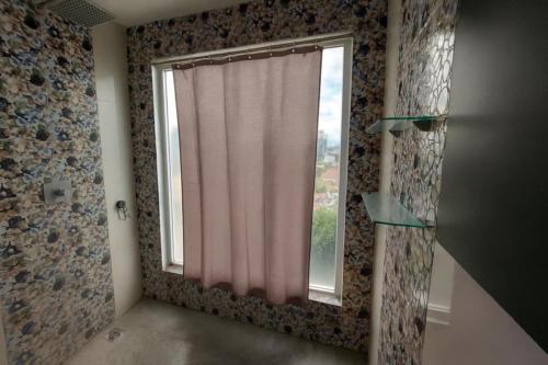 a bathroom with a window with a shower curtain at Condo at Kandi tower 1 in Angeles
