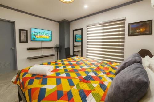 アンヘレスにあるCondo at Kandi tower 1のベッドルーム(カラフルなベッド1台、テレビ付)