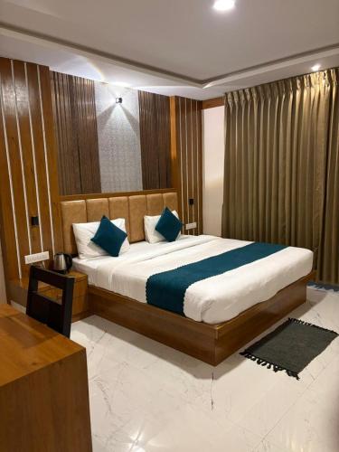 a bedroom with a large bed with blue pillows at Symphony in Ooty