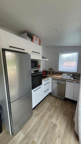 a kitchen with a stainless steel refrigerator and white cabinets at CHALET 3 CHAMBRES - Massif de Belledonne - Haut Bréda in Le Haut-Breda