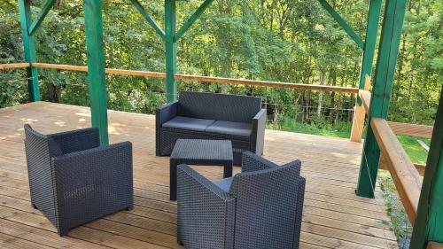 a porch with two chairs and a chair on a wooden deck at CHALET 3 CHAMBRES - Massif de Belledonne - Haut Bréda in Le Haut-Breda