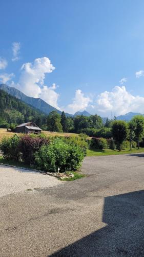 an empty road with a house and mountains in the background at CHALET 3 CHAMBRES - Massif de Belledonne - Haut Bréda in Le Haut-Breda