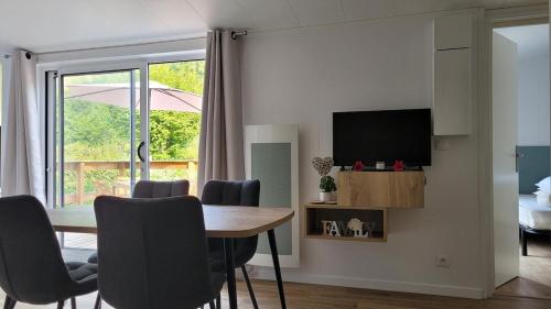 a dining room with a table and chairs and a television at CHALET 3 CHAMBRES - Massif de Belledonne - Haut Bréda in Le Haut-Breda