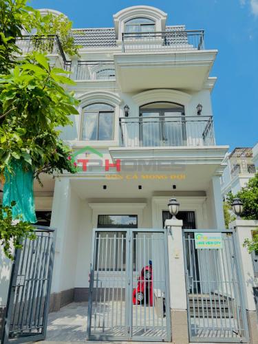 a white building with a gate in front of it at TP-HOMES in Ho Chi Minh City