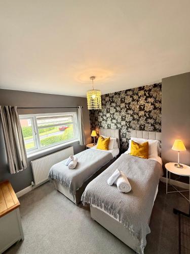 a bedroom with two beds and a window at Home in between Bath and Bristol - Sleeps 9 guests in Keynsham