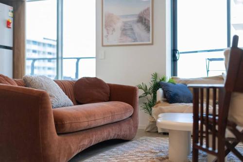 a living room with a brown couch and a table at 2BR Apt in Proximity Hamilton with Carpark in Brisbane