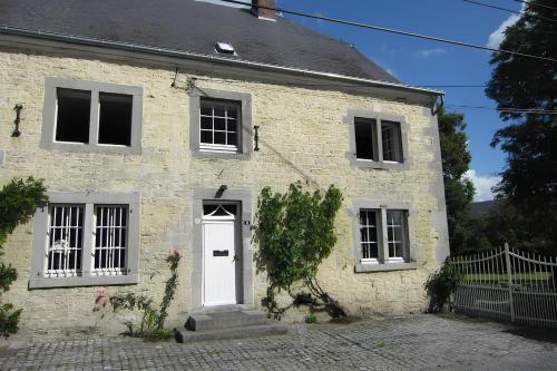 a white brick house with a white door at La Madeleine in Nassogne