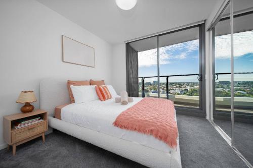 a bedroom with a bed and a large window at 2BR Apt in Proximity Hamilton with Carpark in Brisbane