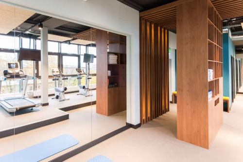 a gym with glass walls and treadmills at Best Western Plus Hotel St. Raphael in Hamburg