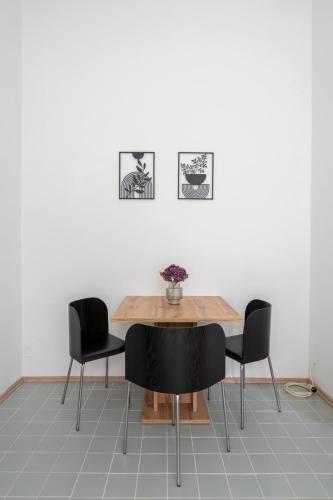 a dining room table with two chairs and a wooden table at FarawayHomes Studios Klosterneuburg in Klosterneuburg