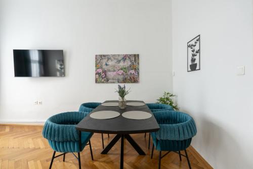 a dining room with a table and blue chairs at FarawayHomes Studios Klosterneuburg in Klosterneuburg
