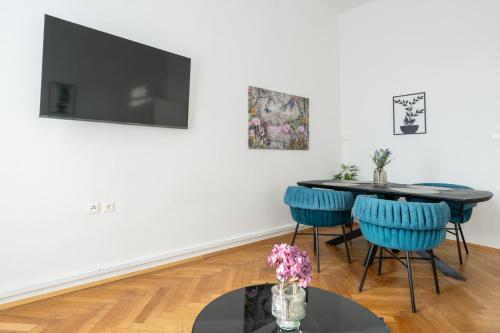 a dining room with a table and blue chairs at FarawayHomes Studios Klosterneuburg in Klosterneuburg