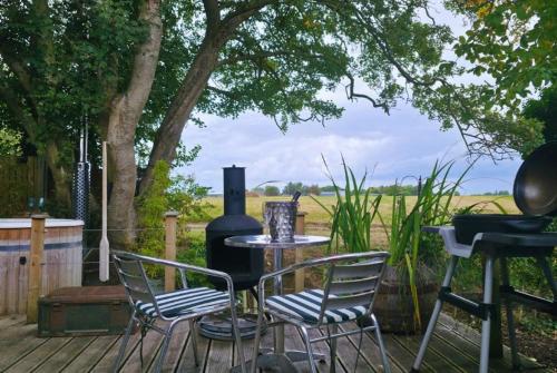 a patio with a table and chairs and a grill at The Pheasant in Great Ellingham