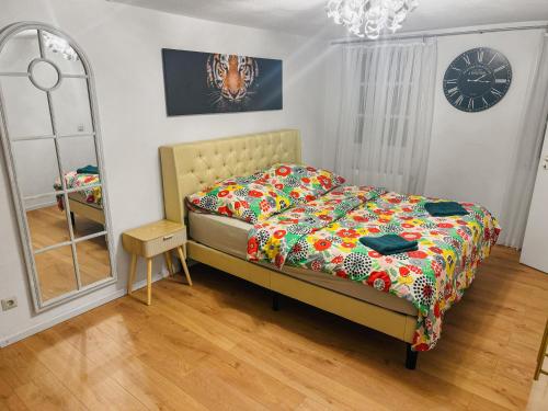 a bedroom with a bed and a mirror and a clock at RheinOase mit Garten für Familien & Gruppen in Koblenz