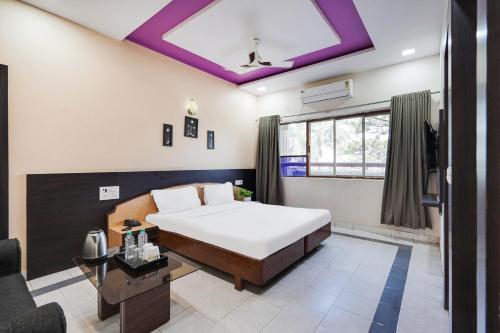 a bedroom with a large bed with a purple ceiling at Palette Bhimpore Daman Formerly Hotel Hilltop in Daman