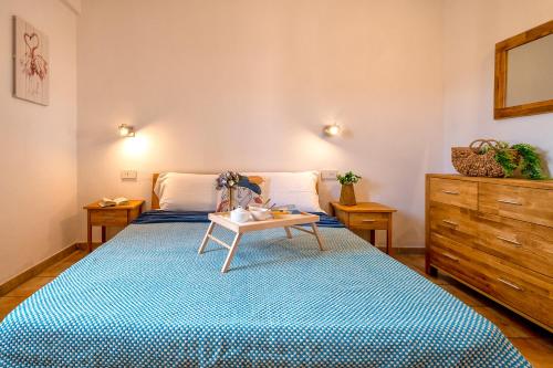a bedroom with a blue bed with a table on it at SORAYA Apartment San Teodoro in San Teodoro