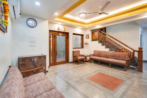a living room with a couch and a staircase at Palette Bhimpore Daman Formerly Hotel Hilltop in Daman