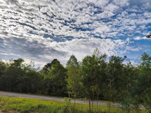 a cloudy sky with trees and a road at Ryhan-Cha Homestay near Afamosa Waterpark in Gua Sai