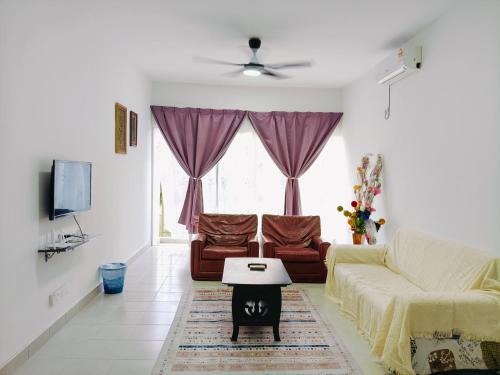 a living room with a couch and a table at Ryhan-Cha Homestay near Afamosa Waterpark in Gua Sai