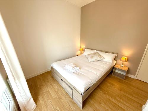 a small bedroom with a bed and two lamps at L'Evasion, proche plage Foncillon - Royan in Royan