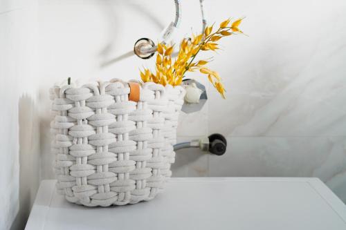 a white vase sitting on a table with a plant in it at Vila Elena in Gevgelija