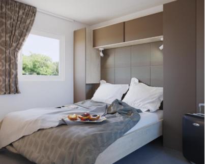 a bedroom with a bed with a tray of food on it at Camping Nord in Klopein am Klopeiner See