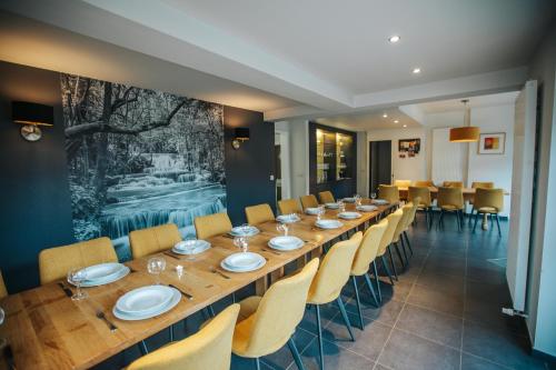 a long dining room with a long table and chairs at Le Bonheur de la Cascade 24 pers - Malmedy, wellness, jardin, confort in Malmedy