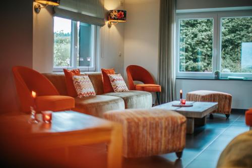a living room with a couch and chairs and windows at Le Bonheur de la Cascade 24 pers - Malmedy, wellness, jardin, confort in Malmedy