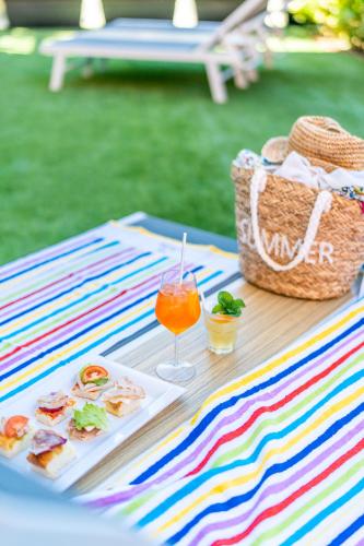 a picnic table with a drink and a basket of food at HOTEL CONTI in San Mauro a Mare