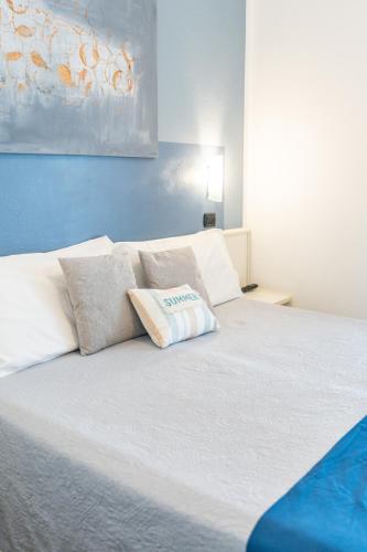 a white bed with pillows on top of it at HOTEL CONTI in San Mauro a Mare