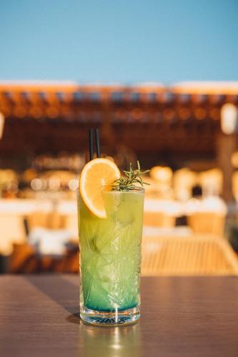a drink with an orange slice sitting on a table at Saint Nicolas Hotel in Himare