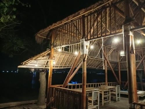a building with a thatched roof at night at Sunset Cabanas Stay Beachfront & Snorkel 