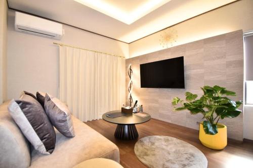 a living room with a couch and a tv on a wall at 瀬の宿 in Takamatsu