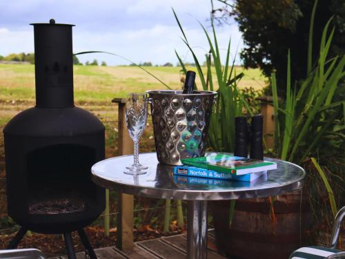 a table with a wine glass and a book and a candle at The Pheasant in Great Ellingham