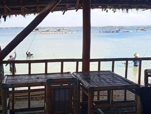 a couple of people on a swing in the water at Sunset Cabanas Stay Beachfront & Snorkel 