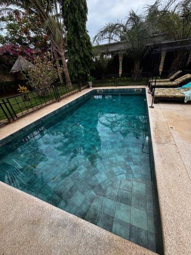 a swimming pool with blue water in a yard at Modern villa with pool views in Ngaparou