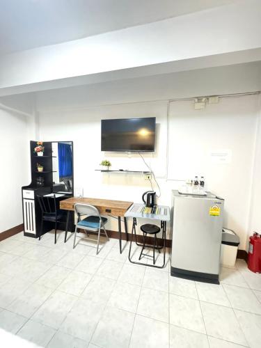 a room with a table and chairs and a refrigerator at La Casa Patong in Patong Beach
