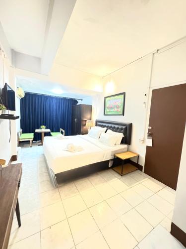 a large room with two beds and a table at La Casa Patong in Patong Beach