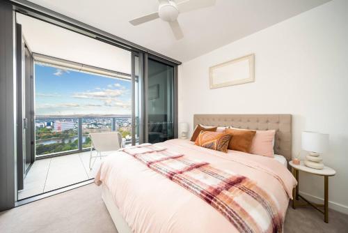 Un dormitorio con una cama y una ventana grande en Queen's Wharf 1B+Study, en Brisbane