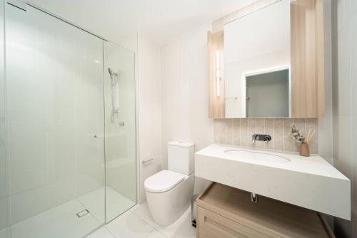 Un baño con inodoro, lavabo y ducha. en Queen's Wharf 1B+Study, en Brisbane