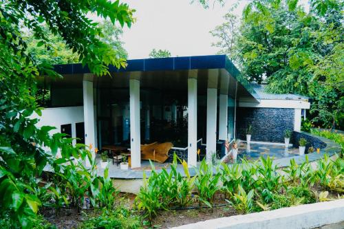a house with a blue roof and columns at Birds Nest Resort in Kinlivli