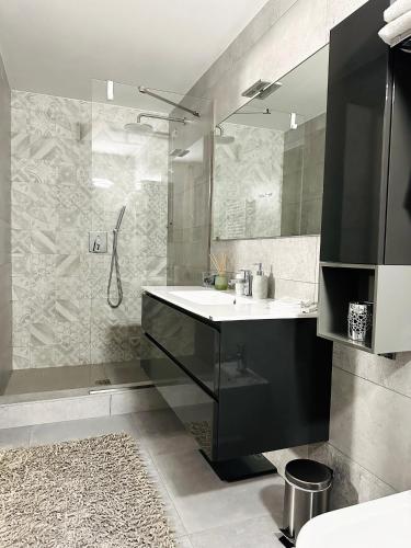 a bathroom with a sink and a shower with a mirror at Paradise Luxury apartments in Sirmione