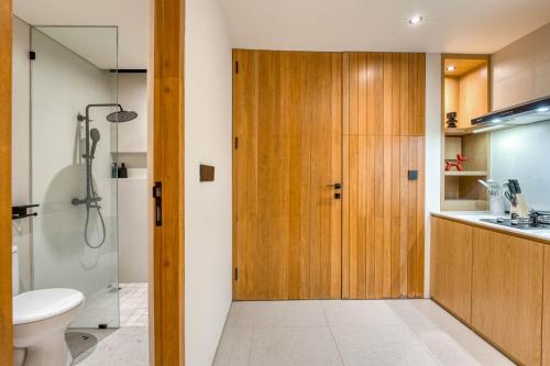 a bathroom with a shower and a toilet and a sink at Tegeh Townhouse Complex Modern 1BR In Uluwatu in Ungasan